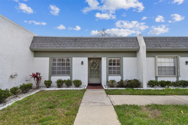 view of exterior entry with a yard