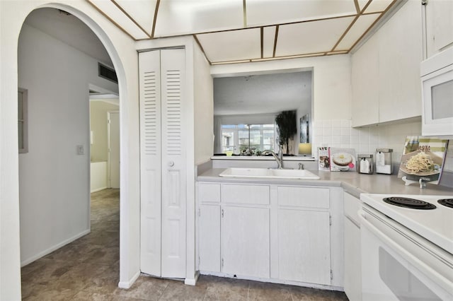 kitchen featuring sink, white appliances, decorative backsplash, and white cabinets