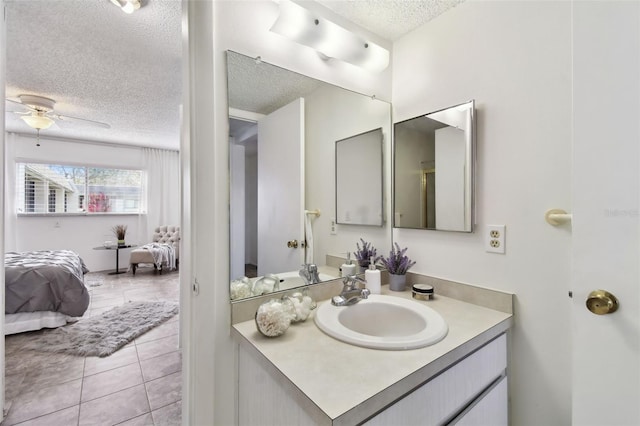 bathroom with tile patterned flooring, vanity, a textured ceiling, and ceiling fan