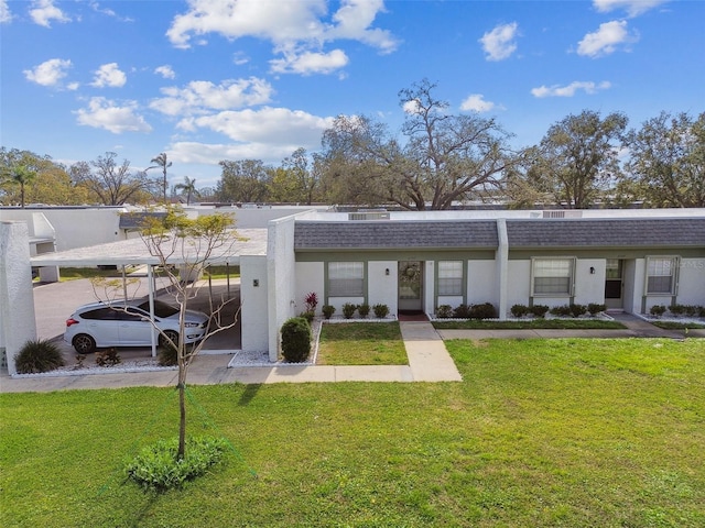 back of house with a carport and a lawn