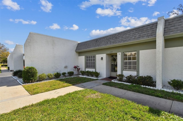 view of exterior entry with a yard