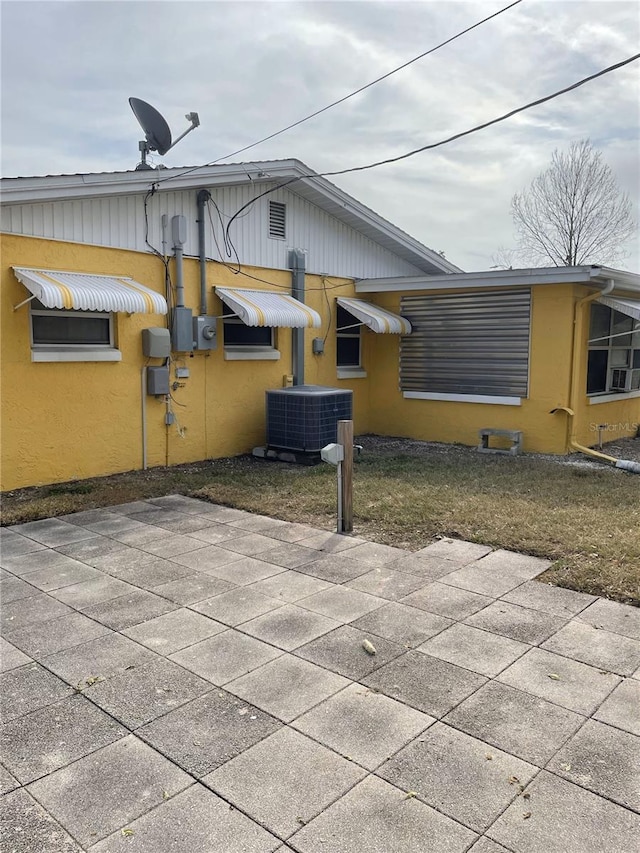 rear view of property featuring central AC unit