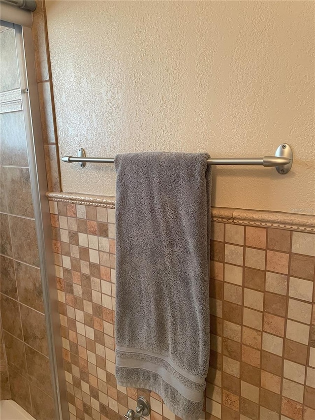 bathroom with tiled shower and tile walls