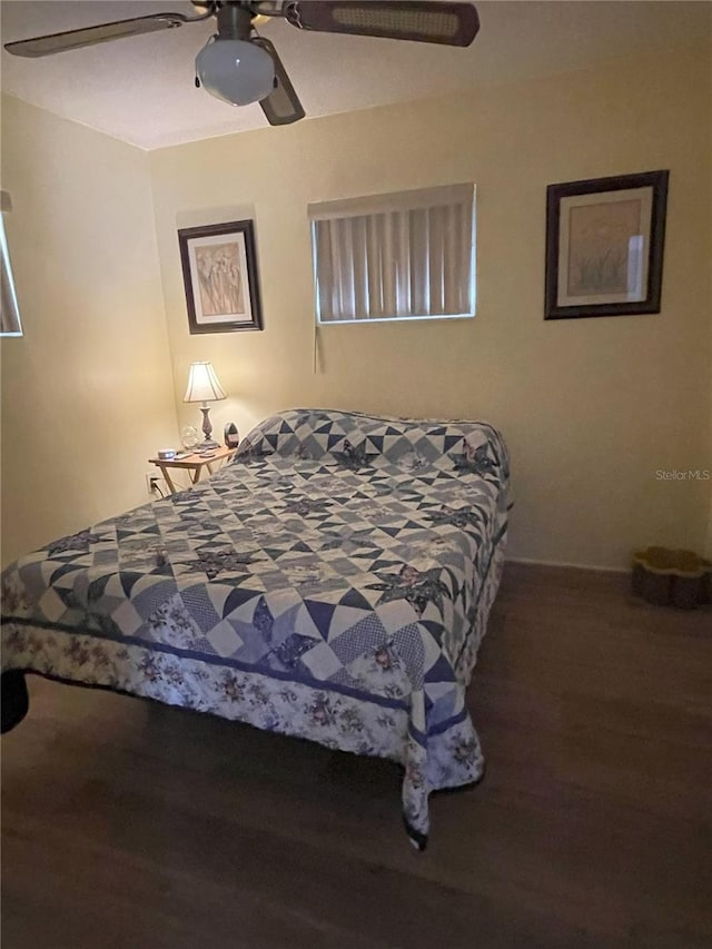 bedroom with dark hardwood / wood-style floors and ceiling fan