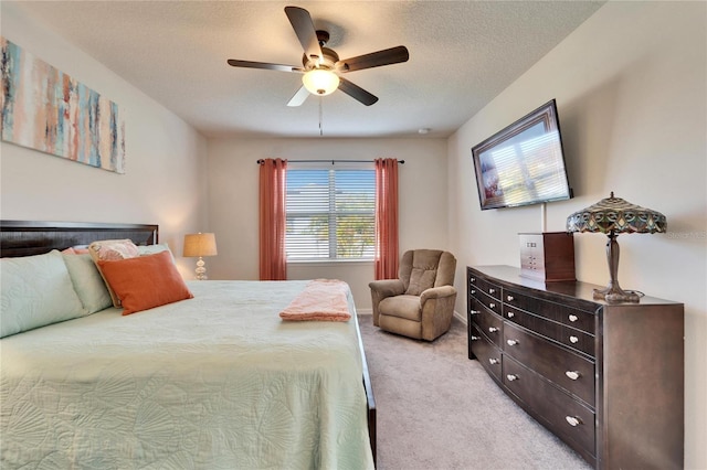 carpeted bedroom with ceiling fan and a textured ceiling