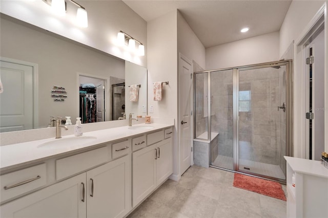 bathroom with a shower with door, vanity, and tile patterned floors