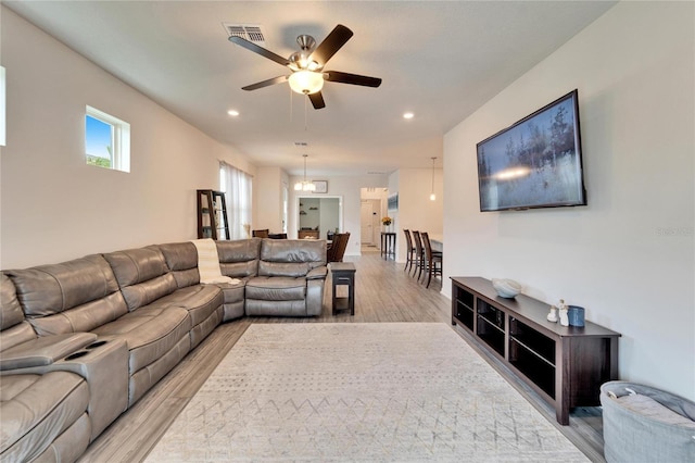 living room with ceiling fan and light wood-type flooring