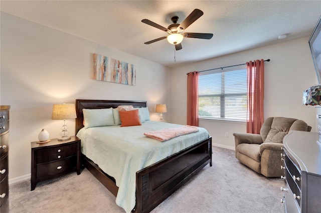 carpeted bedroom with ceiling fan and a textured ceiling