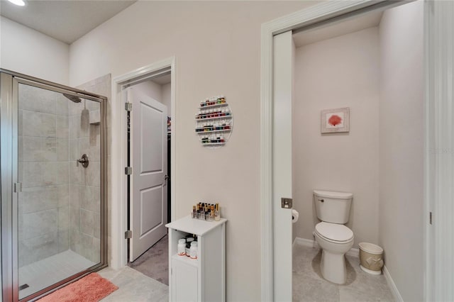 bathroom with tile patterned floors, toilet, and walk in shower