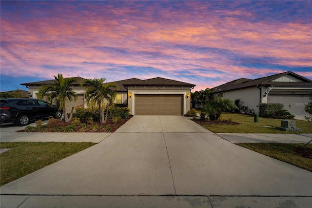 view of front of house with driveway, stucco siding, a garage, and a front yard