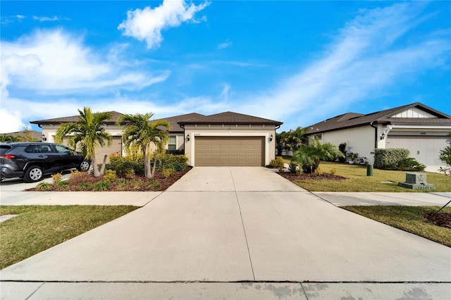 view of front of house featuring a garage, driveway, a front yard, and stucco siding