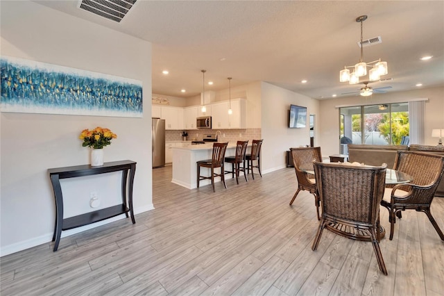 dining room featuring light wood-type flooring, visible vents, and recessed lighting