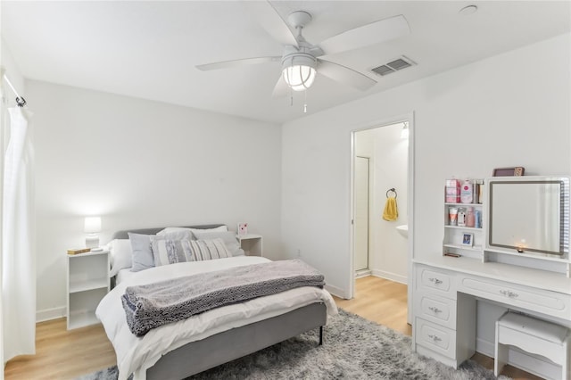 bedroom featuring ceiling fan, ensuite bathroom, and light hardwood / wood-style flooring