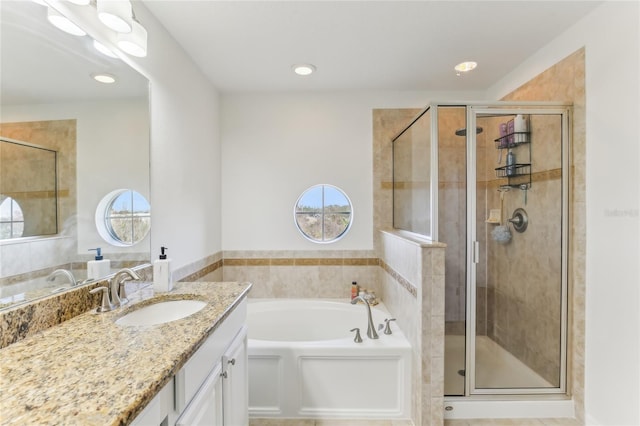 bathroom featuring vanity, separate shower and tub, and a wealth of natural light