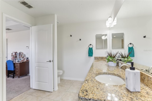 bathroom featuring vanity, tile patterned floors, and toilet