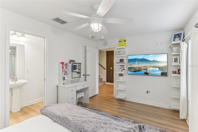 bedroom with connected bathroom, sink, ceiling fan, and light wood-type flooring