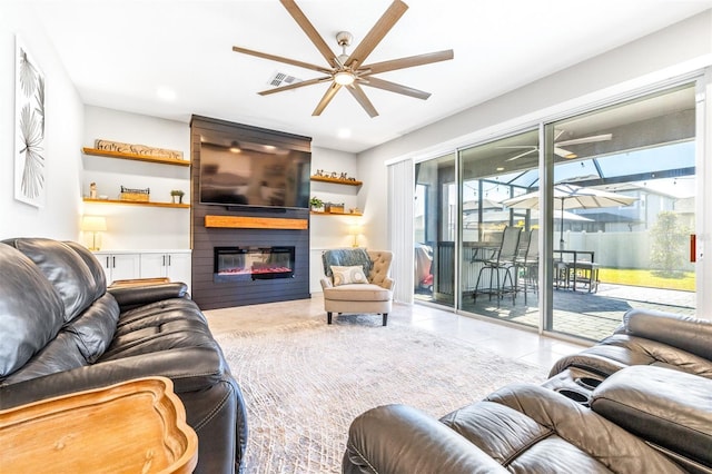 tiled living room with a large fireplace and ceiling fan