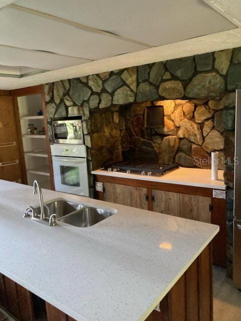 kitchen featuring appliances with stainless steel finishes, sink, and a fireplace