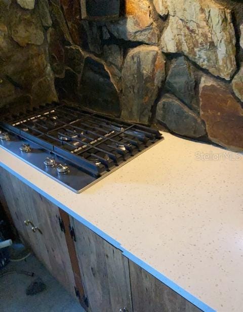 details with gas stovetop and tasteful backsplash