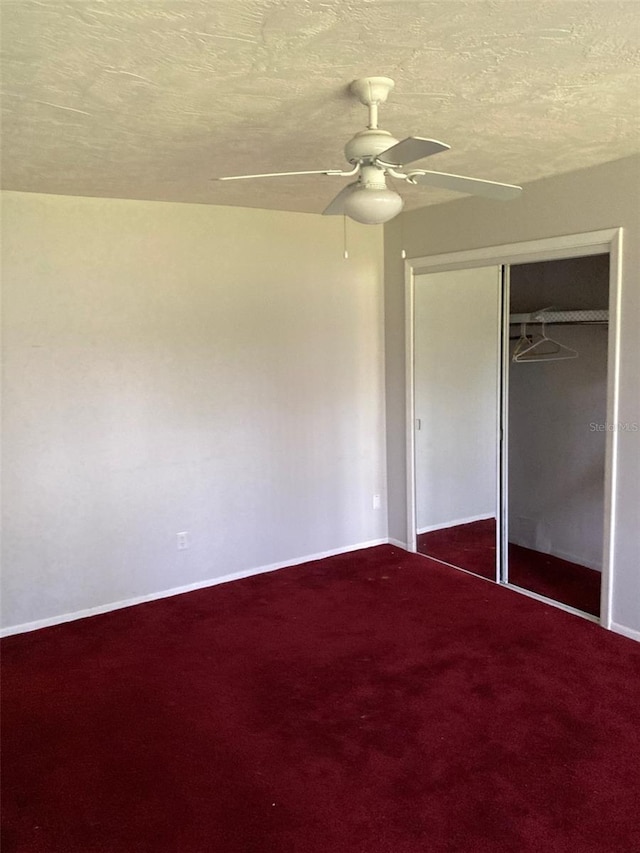 unfurnished bedroom featuring ceiling fan, carpet, a textured ceiling, and a closet