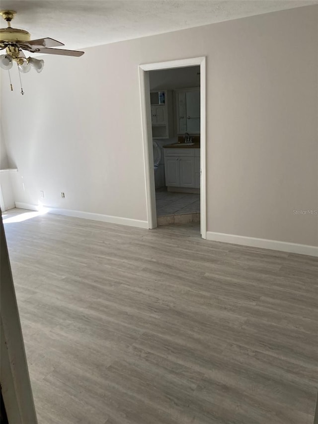 empty room featuring wood-type flooring, sink, a textured ceiling, and ceiling fan