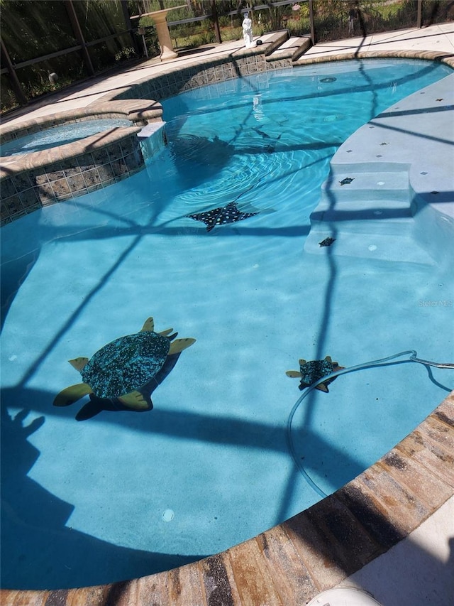 view of pool featuring an in ground hot tub