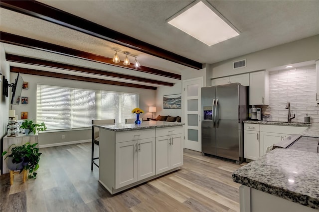 kitchen with white cabinetry, light stone countertops, sink, and stainless steel fridge with ice dispenser