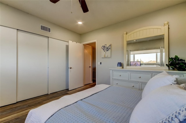 bedroom featuring dark wood-type flooring, ceiling fan, and a closet