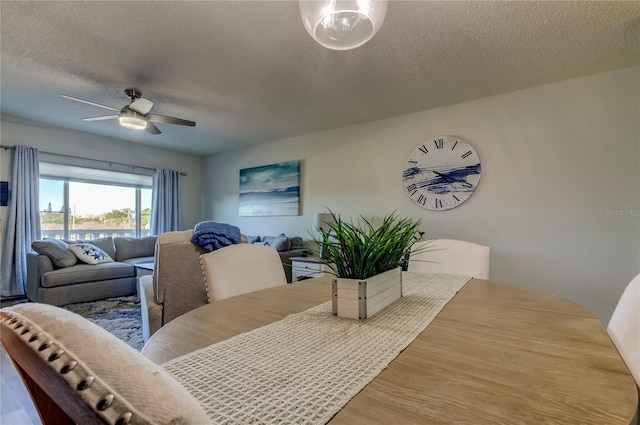 dining room with hardwood / wood-style flooring, ceiling fan, and a textured ceiling