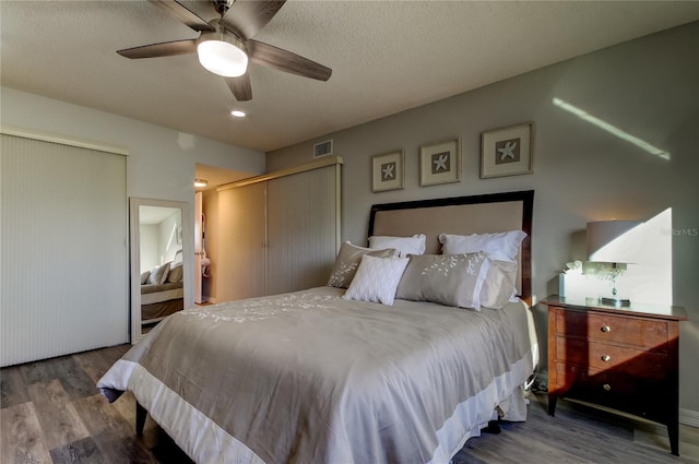 bedroom with ceiling fan, hardwood / wood-style flooring, and a textured ceiling