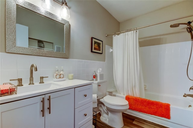 full bathroom with shower / tub combo with curtain, hardwood / wood-style flooring, tile walls, vanity, and toilet