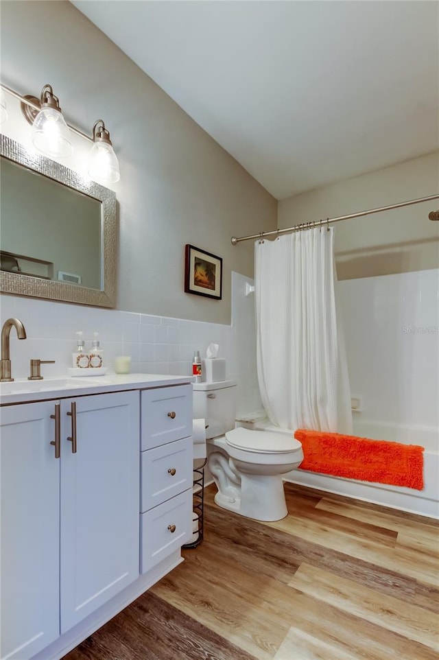 bathroom featuring vanity, toilet, hardwood / wood-style floors, and decorative backsplash