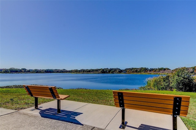 view of home's community featuring a lawn and a water view