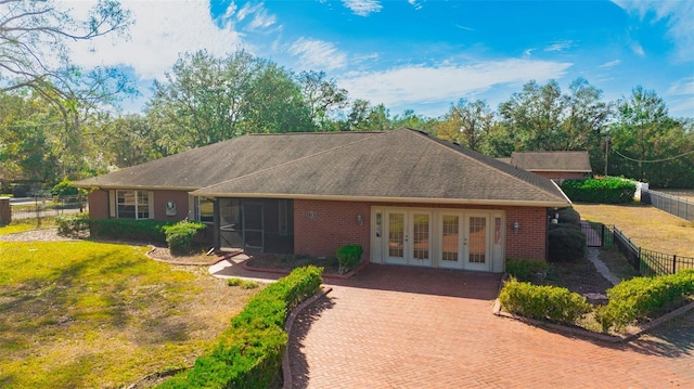 back of house with a sunroom, a yard, and french doors