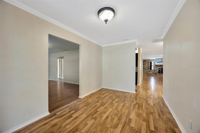 interior space featuring hardwood / wood-style floors, ornamental molding, and a large fireplace