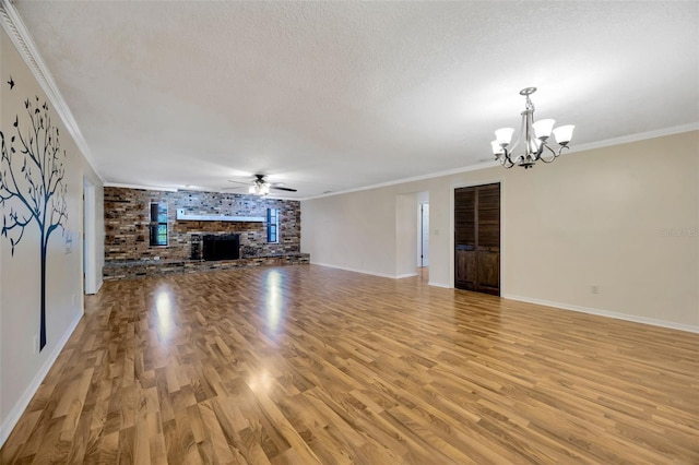 unfurnished living room with ceiling fan with notable chandelier, light hardwood / wood-style floors, crown molding, a brick fireplace, and a textured ceiling