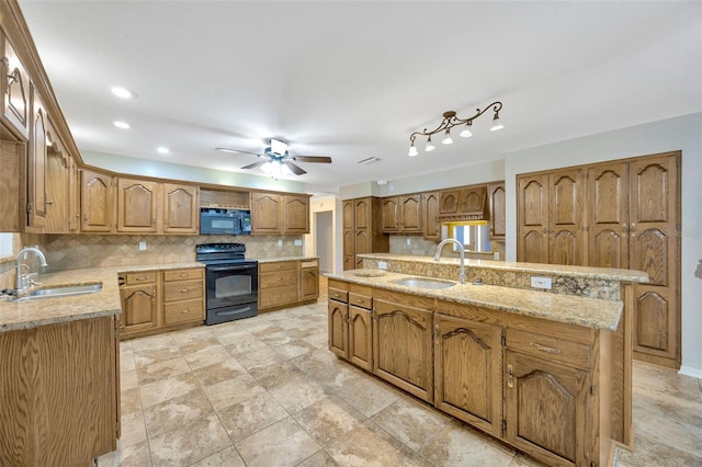 kitchen featuring a center island, sink, decorative backsplash, and black appliances