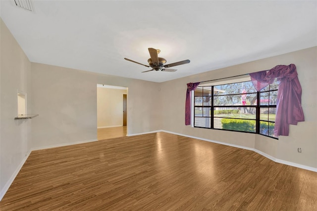 empty room with hardwood / wood-style flooring and ceiling fan