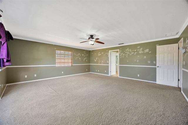 carpeted spare room with crown molding and ceiling fan