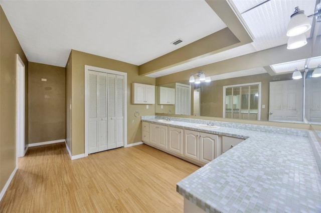 kitchen featuring sink, white cabinets, and light hardwood / wood-style flooring