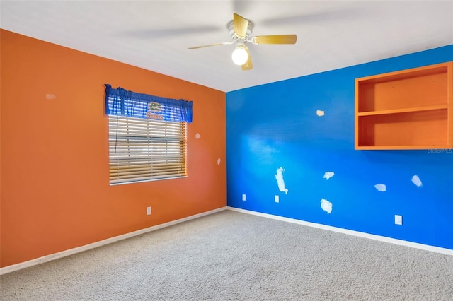 carpeted spare room with ceiling fan