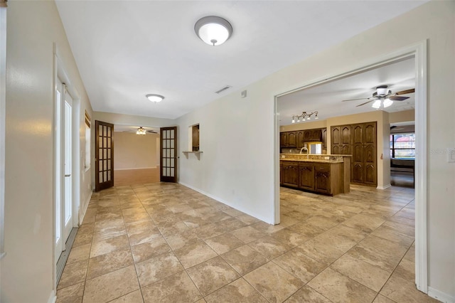 unfurnished room with french doors and ceiling fan