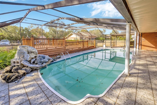 view of swimming pool featuring a deck and glass enclosure