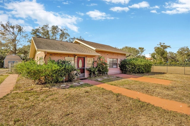 view of front of house with a storage unit and a front yard