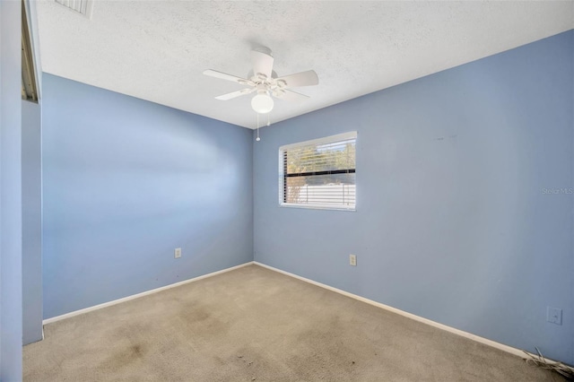 carpeted spare room with ceiling fan and a textured ceiling