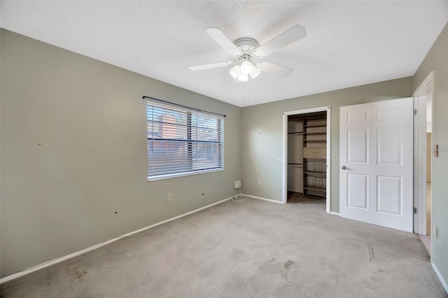 unfurnished bedroom featuring light carpet, a textured ceiling, ceiling fan, and a closet