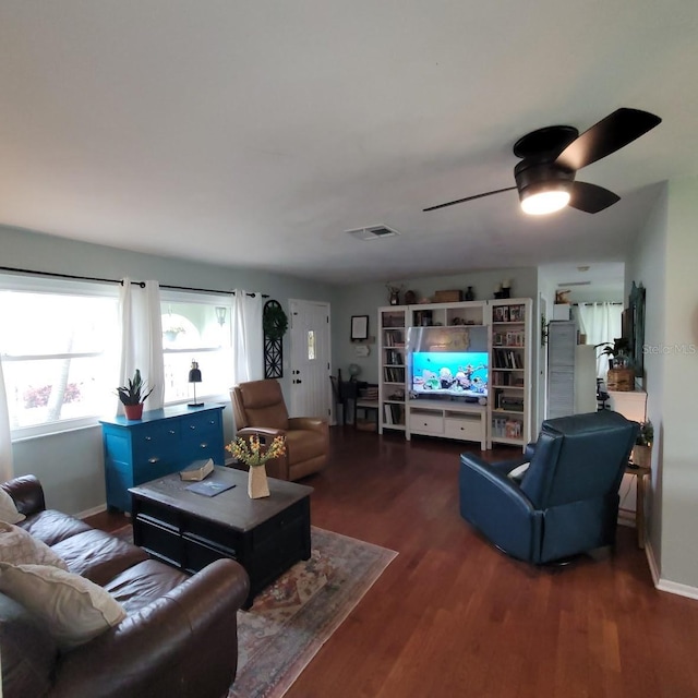 living room featuring dark wood-type flooring and ceiling fan