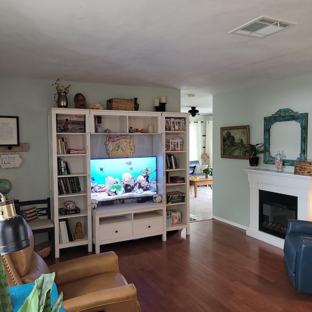 living room featuring dark wood-type flooring and ceiling fan