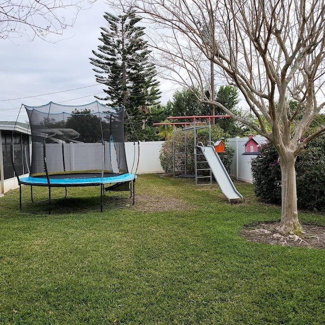 view of yard featuring a playground and a trampoline