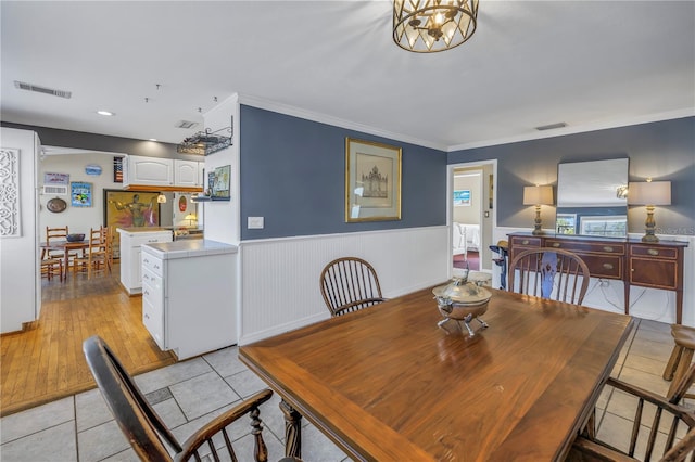 tiled dining space featuring ornamental molding